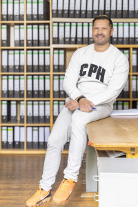 Ein männlicher Mitarbeiter in hellem Shirt und heller Hose in der Steuerberatung Bettina Baur Frankfurt-Höchst.